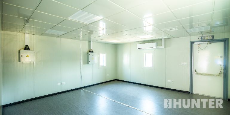 Interior view of a Hunter blast-resistant TAR building with white walls and ceiling, and gray flooring 